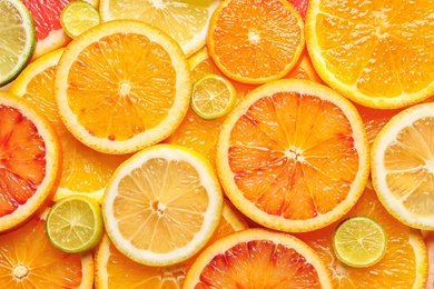 Slices of fresh citrus fruits as background, top view