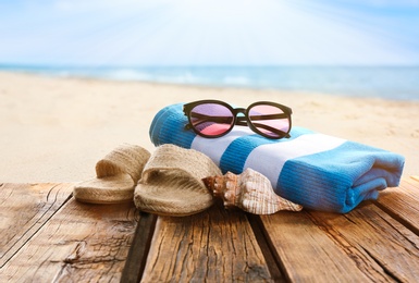 Beach accessories on wooden surface near ocean 