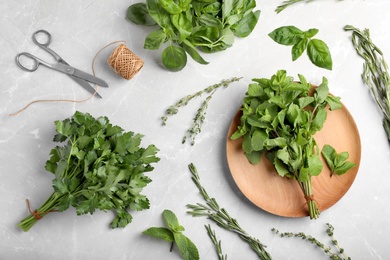 Flat lay composition with fresh green herbs on grey background