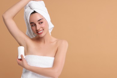 Photo of Beautiful woman applying deodorant on beige background, space for text