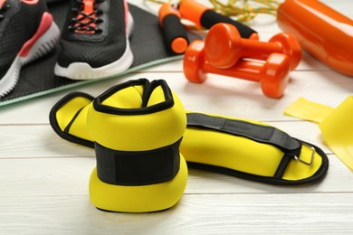 Photo of Yellow weighting agents and sport equipment on white wooden table