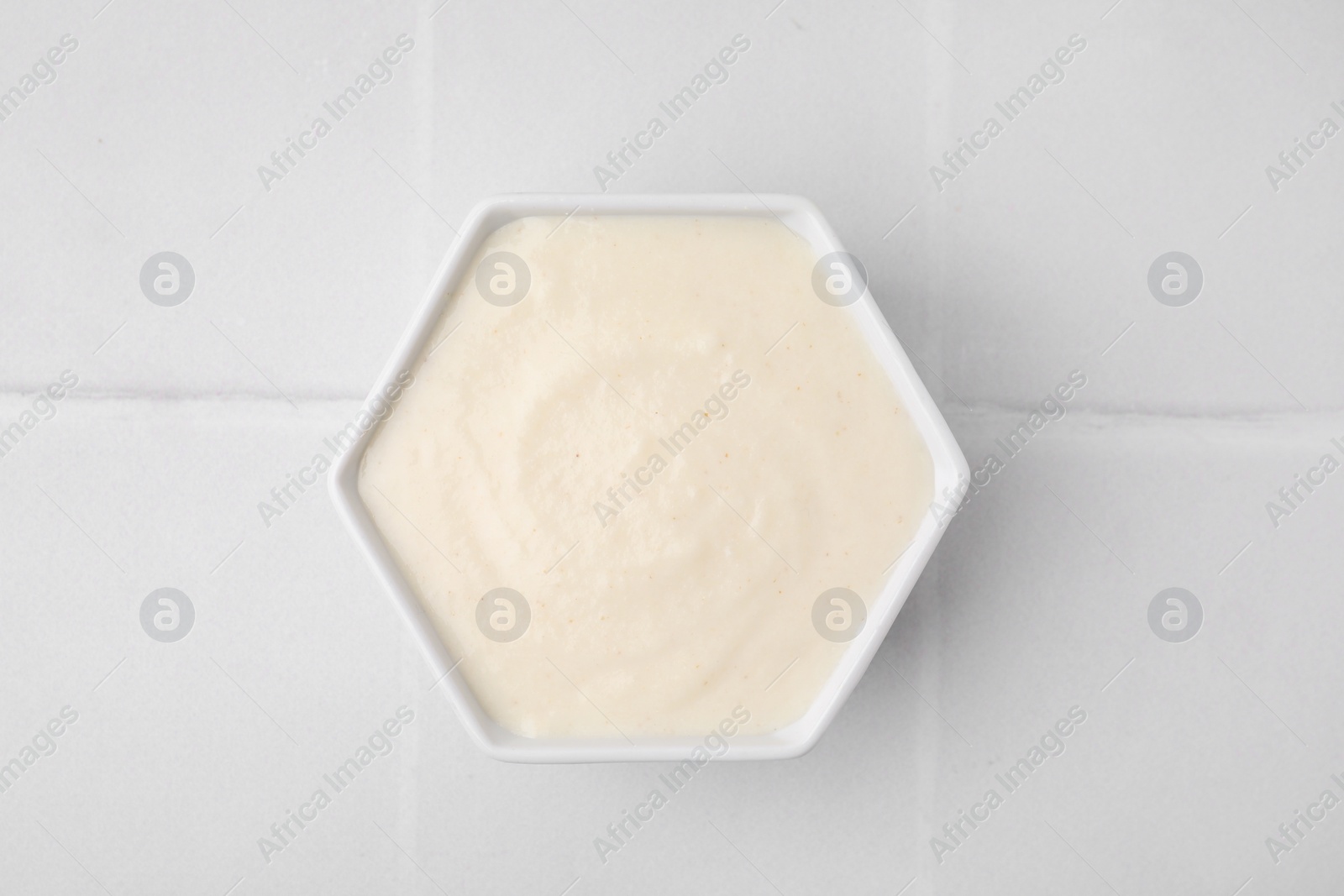 Photo of Bowl of delicious semolina pudding on white table, top view
