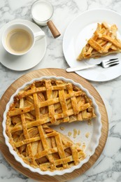 Photo of Tasty homemade quince pie served on white marble table, flat lay