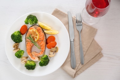 Photo of Plate with salmon steak and garnish prepared in multi cooker on table, flat lay