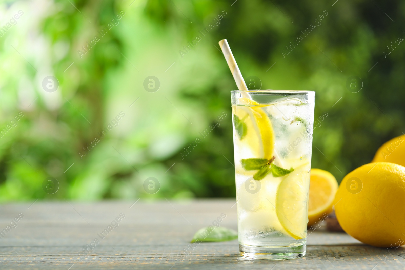 Photo of Cool freshly made lemonade and fruits on grey wooden table. Space for text