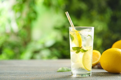 Cool freshly made lemonade and fruits on grey wooden table. Space for text