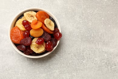 Mix of delicious dried fruits on grey table, top view. Space for text