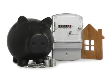 Electricity meter, house model, piggy bank and coins on white background