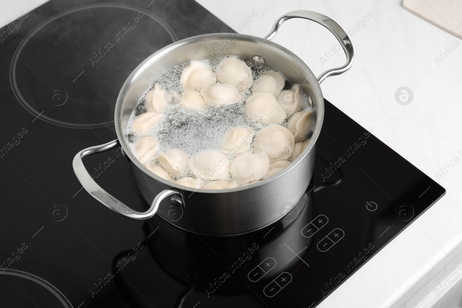 Photo of Cooking delicious dumplings in pot on cooktop