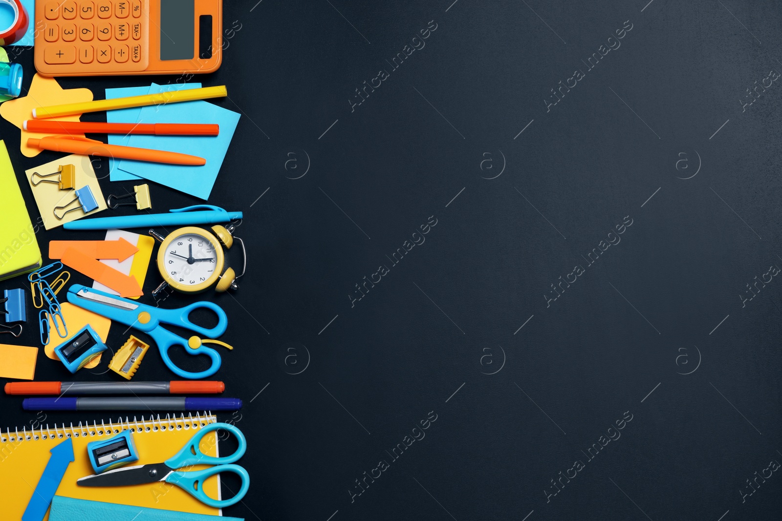 Photo of Flat lay composition with school stationery on black chalkboard, space for text