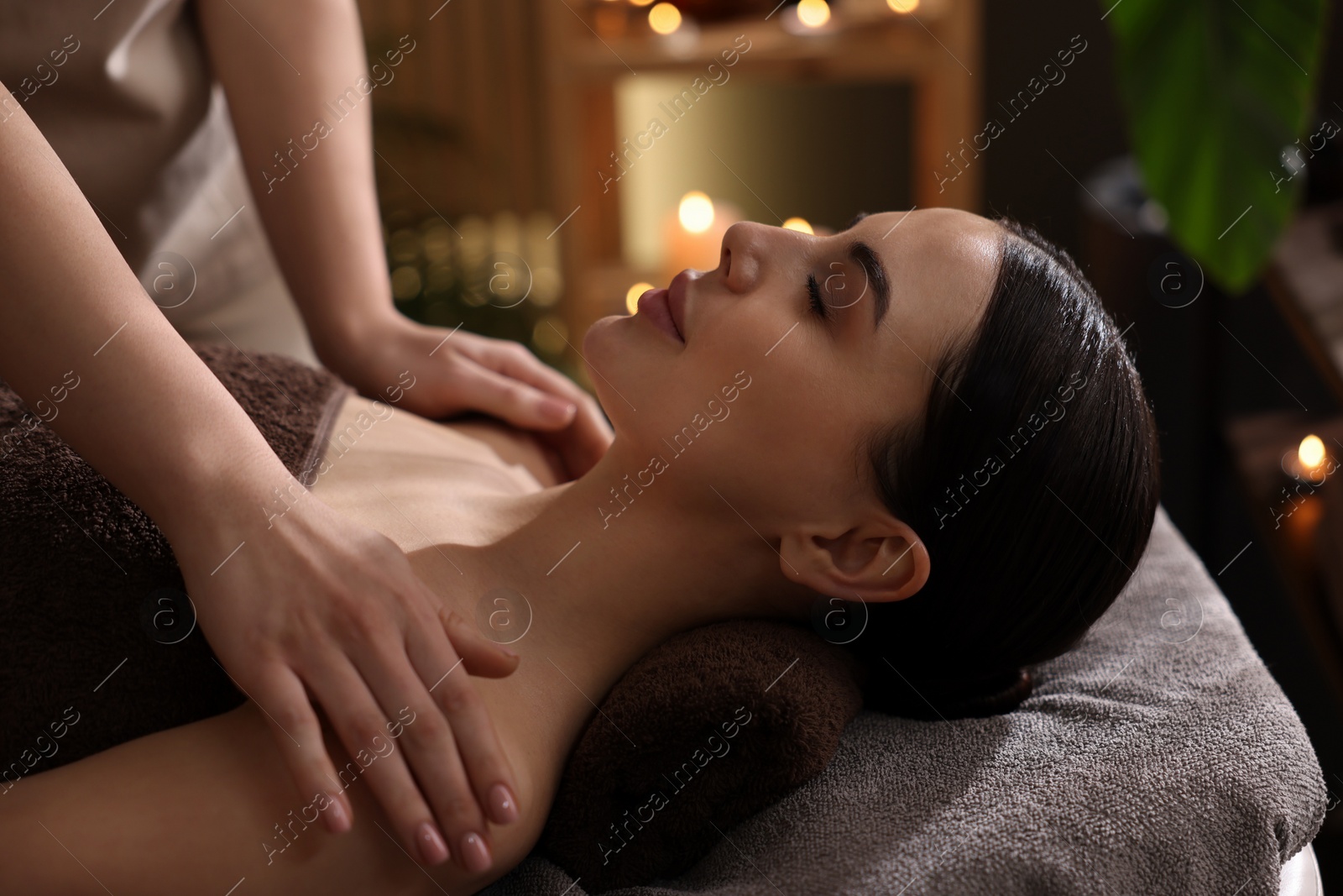 Photo of Spa therapy. Beautiful young woman lying on table during massage in salon