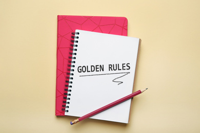 Image of Flat lay composition of notebook with words GOLDEN RULES on beige background