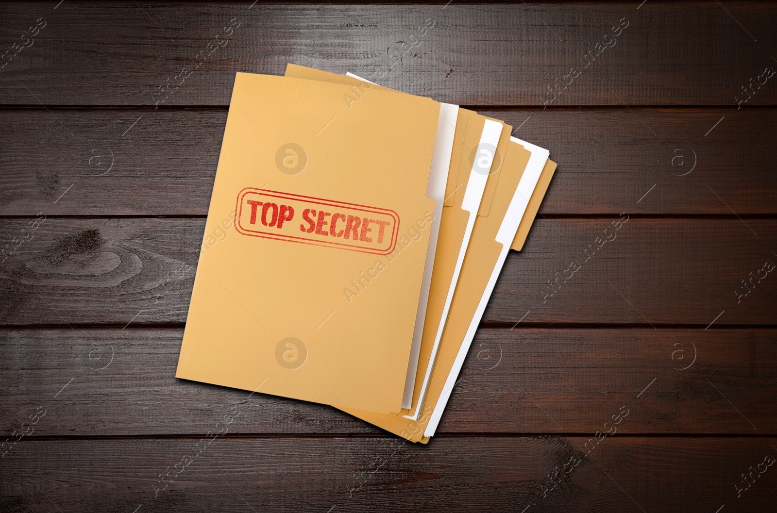 Image of Top Secret stamp. Files with documents on wooden table, top view