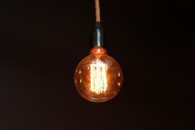 Photo of Glowing lamp bulb in darkness. Interior element