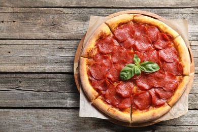 Tasty pepperoni pizza on wooden table, top view. Space for text