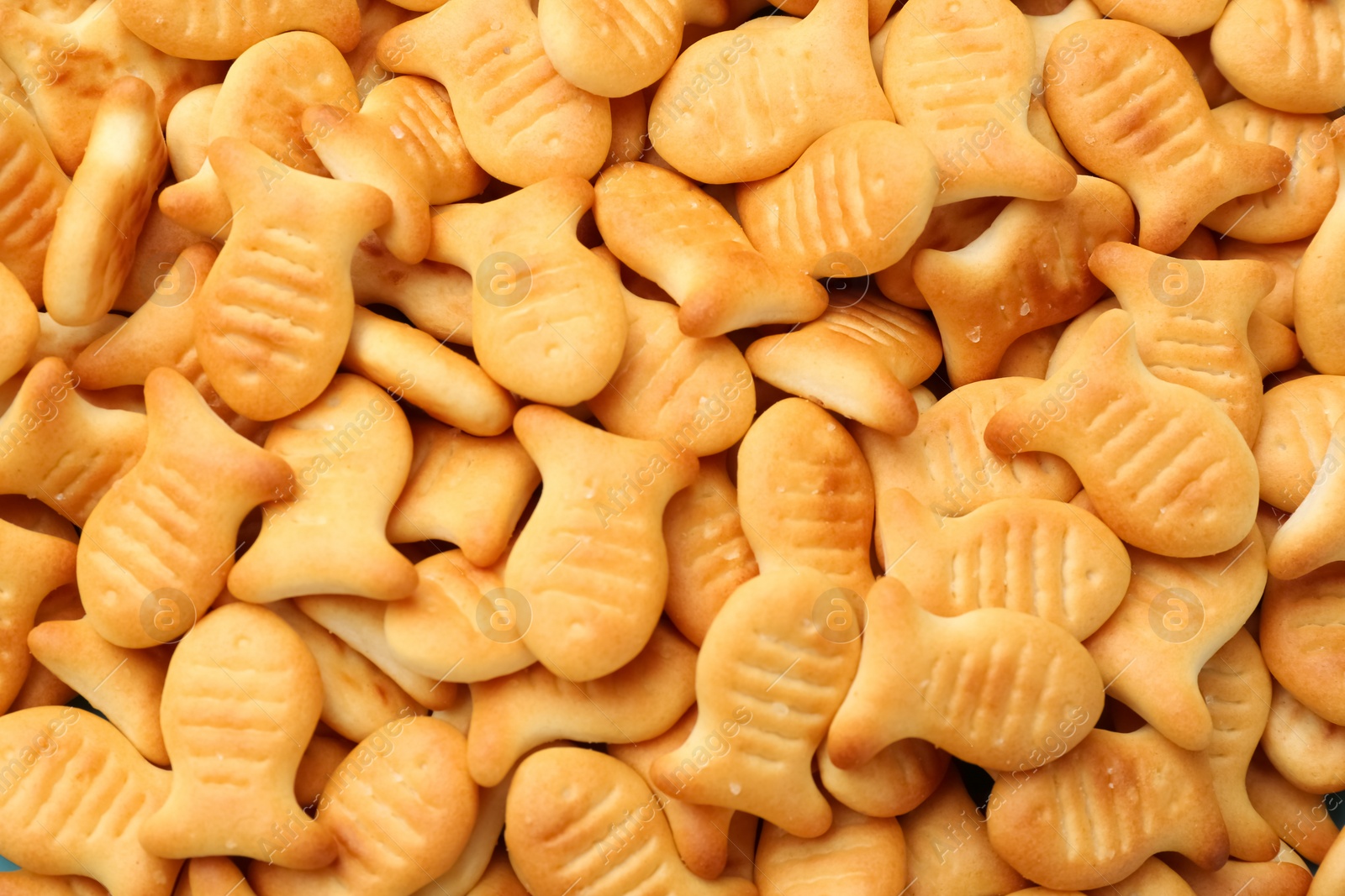 Photo of Delicious goldfish crackers as background, closeup view