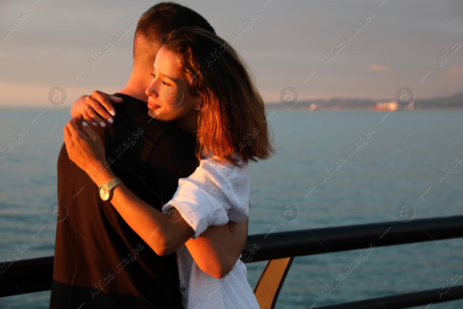 Photo of Happy young couple hugging on sea embankment