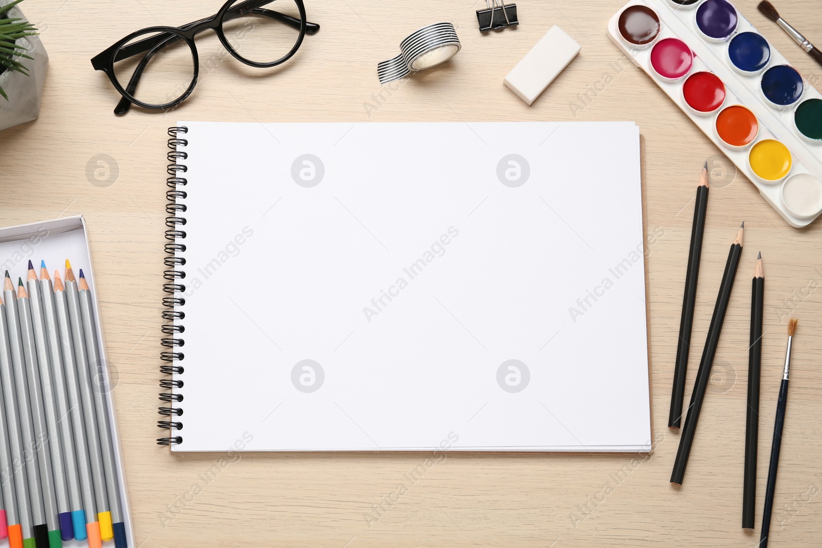 Photo of Flat lay composition with blank sketchbook on wooden table. Space for text