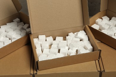 Many closed and open cardboard boxes with pieces of polystyrene foam as background