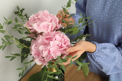 Photo of Woman with bouquet of beautiful hortensia flowers indoors, closeup