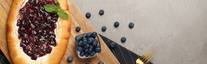 Image of Delicious sweet cottage cheese pastry with jam served on grey table, flat lay. Banner design with space for text