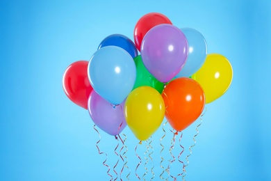 Photo of Bunch of bright balloons on color background