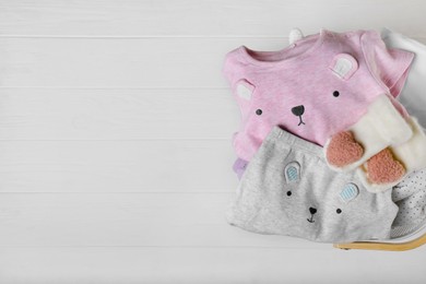 Photo of Laundry basket with baby clothes on white wooden table, top view. Space for text