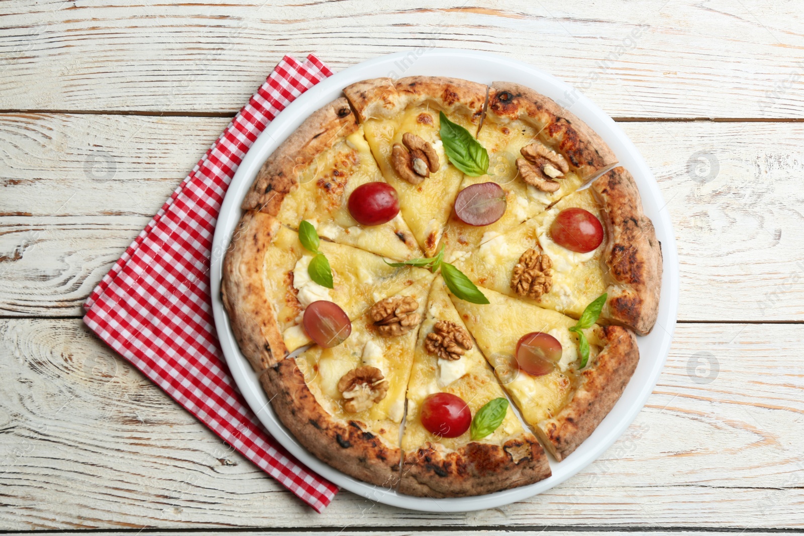 Photo of Delicious cheese pizza with walnuts and grapes on white wooden table, top view