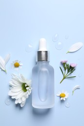 Photo of Bottle of cosmetic serum, flowers and petals on light blue background, flat lay