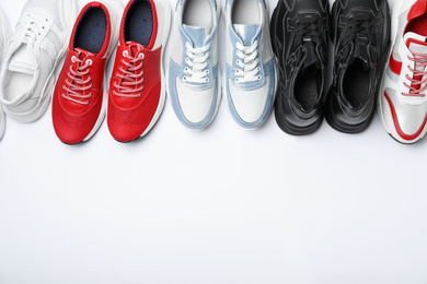 Photo of Many stylish sneakers on white background, top view