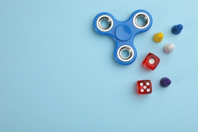 Photo of Spinner, dices and pawns on light blue background, flat lay with space for text. Board games components