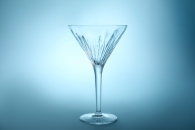Photo of Elegant empty martini glass on light blue background