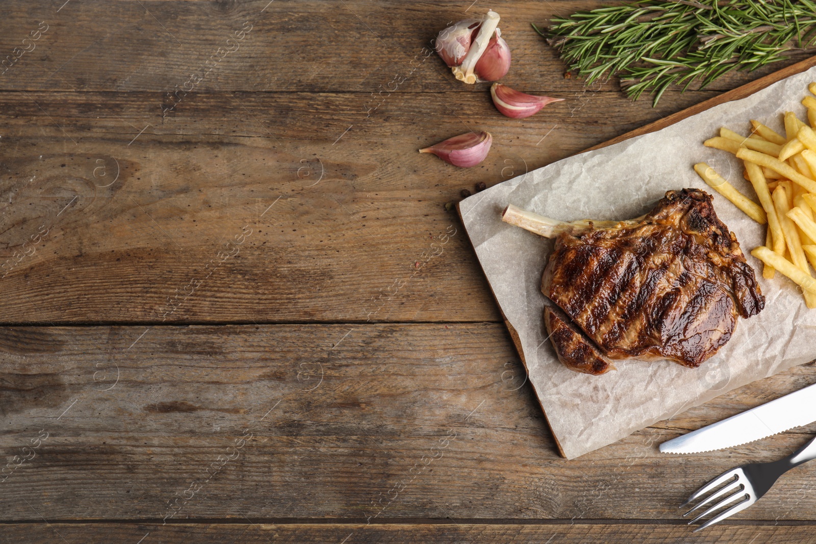 Photo of Flat lay composition with grilled beef steak on wooden table, space for text