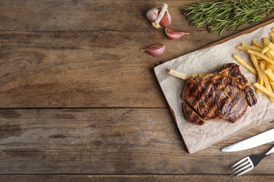 Photo of Flat lay composition with grilled beef steak on wooden table, space for text