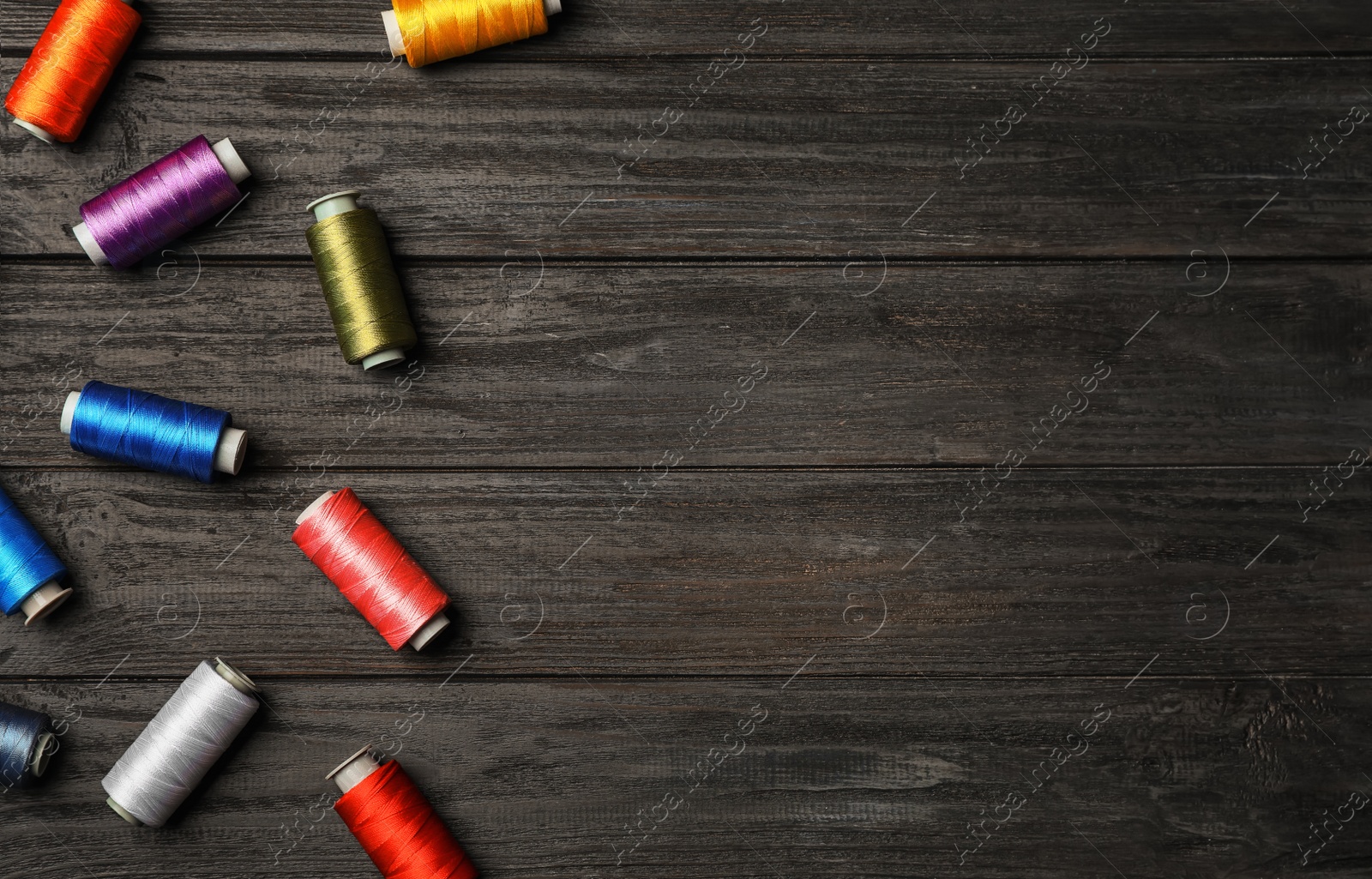 Photo of Flat lay composition with sewing threads on wooden background