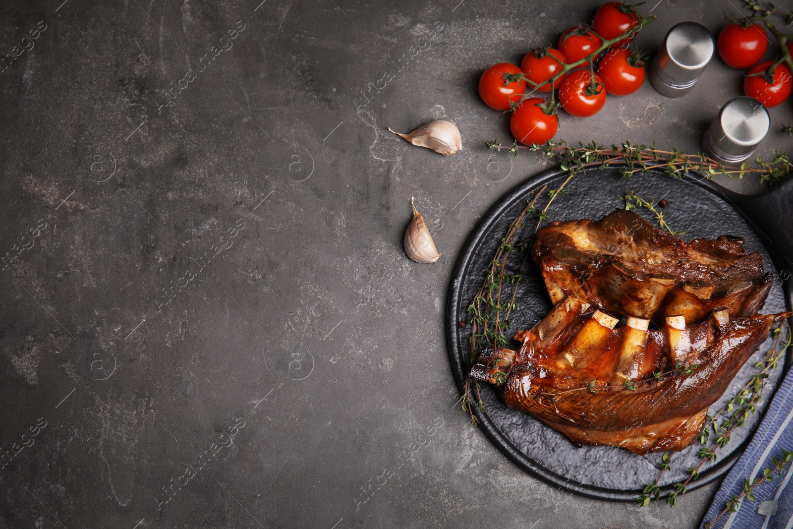 Photo of Delicious roasted ribs served on grey table, flat lay. Space for text