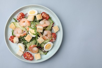 Photo of Delicious Caesar salad with shrimps on grey background, top view. Space for text