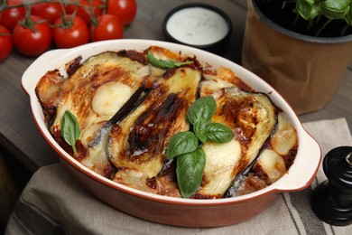 Photo of Delicious eggplant lasagna in baking dish on wooden table