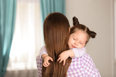 Photo of Young mother with little daughter at home
