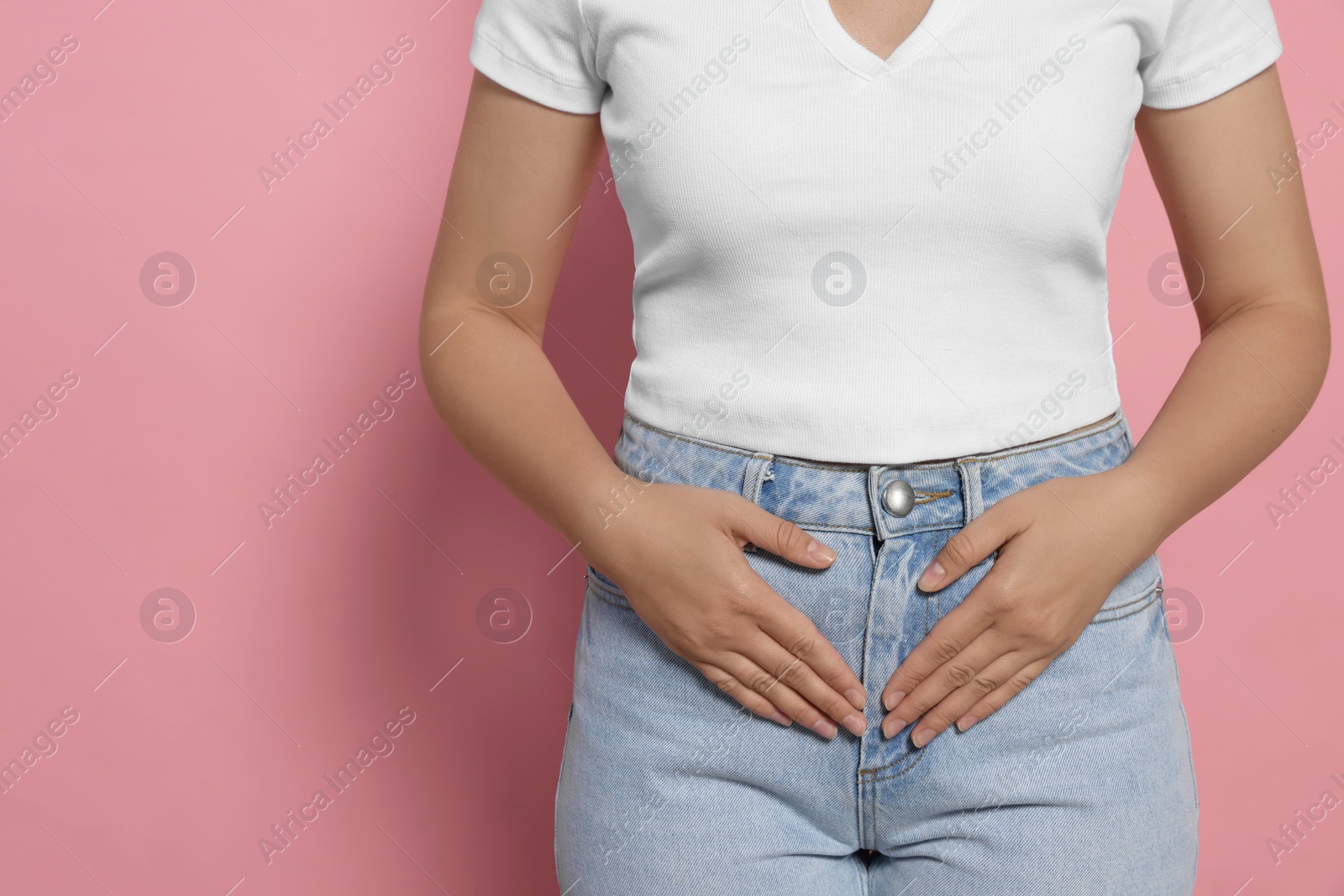 Photo of Young woman suffering from menstrual pain on pink background, closeup