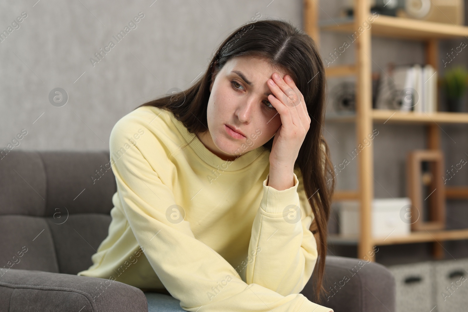 Photo of Overwhelmed woman sitting in armchair at home