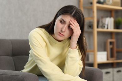 Photo of Overwhelmed woman sitting in armchair at home