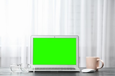 Image of Laptop display with chroma key on desk in room. Comfortable workplace with modern computer