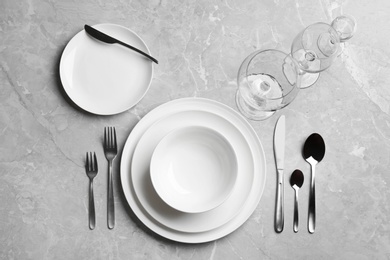 Elegant table setting on grey marble background, flat lay