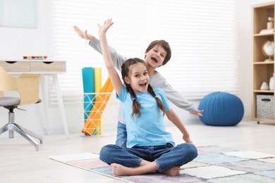 Happy brother and sister spending time together at home