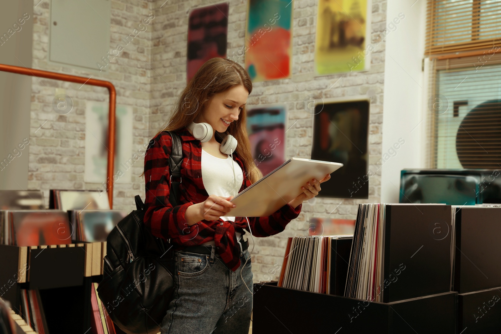 Image of Young woman with vinyl record in store