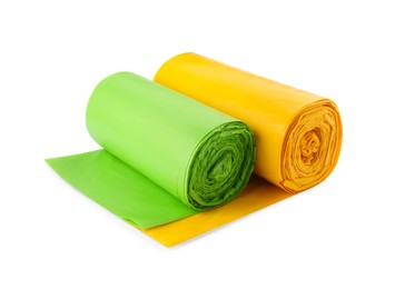 Photo of Rolls of green and yellow garbage bags on white background