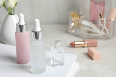 Photo of Bottles of cosmetic products on light grey table, space for text