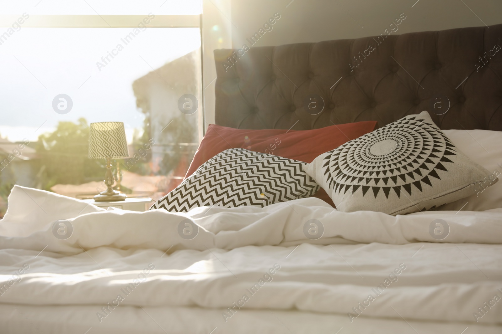 Photo of Different pillows on bed in room. Idea for interior decor