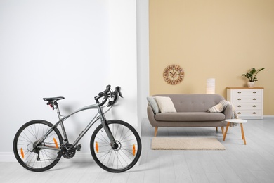 Photo of Modern apartment interior with bicycle near wall. Space for text